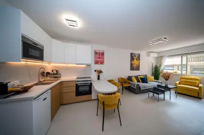 a kitchen and living room with a couch and a table at Luxe 1 minute a pied du Martinez plage shopping vu Mer in Cannes