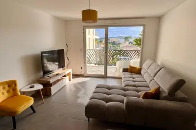 a living room with a couch and a television at Charming 3 rooms located in Le Cannet near Cannes in Le Cannet