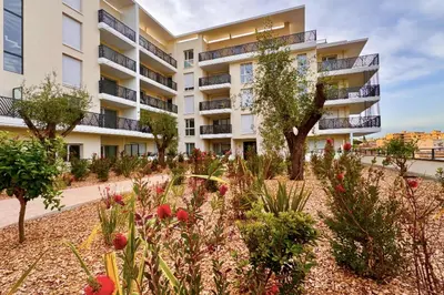 an apartment building with a garden in front of it at Charming 3 rooms located in Le Cannet near Cannes in Le Cannet