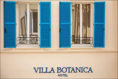 a facade with blue shutters on a building at Hotel Villa Botanica in Cannes