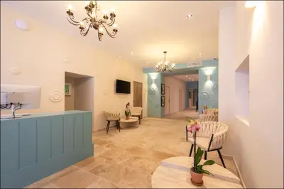 a lobby with a waiting room with chairs and a chandelier at Hotel Villa Botanica in Cannes