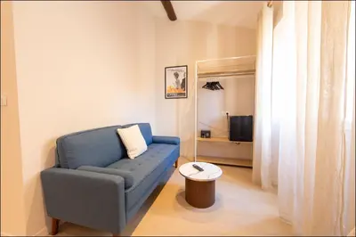 a bedroom with a bed with white sheets and a mirror at Hotel Villa Botanica in Cannes