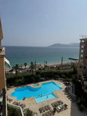 a view of a swimming pool and the beach at Pierre Vacances VUE MER 748 in Cannes