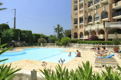 a group of people sitting in a swimming pool next to a building at T2 Mer et Piscine Cannes 4 pers in Cannes