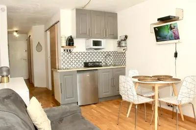 a kitchen and a living room with a table and chairs at T2 Mer et Piscine Cannes 4 pers in Cannes