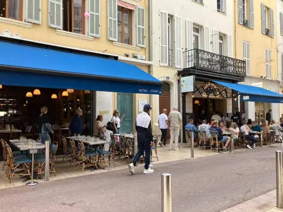 a man walking down a street in front of a restaurant at Cannes Banane in Cannes