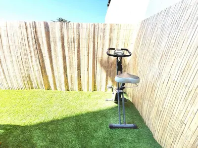 a chair sitting in the grass next to a fence at Cannes Banane in Cannes
