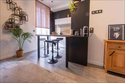 a kitchen with a counter and stools in a room at LE COCON DE JAURÈS entre Gare Croisette et Palais in Cannes