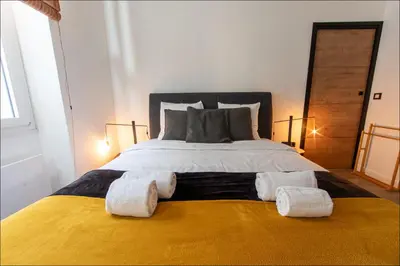 a bedroom with a large bed with towels on it at LE COCON DE JAURÈS entre Gare Croisette et Palais in Cannes