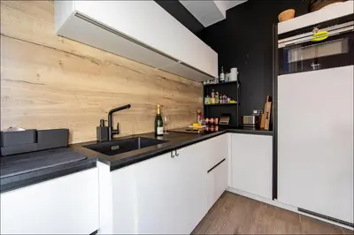 a kitchen with white cabinets and a sink at LE COCON DE JAURÈS entre Gare Croisette et Palais in Cannes