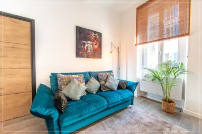 a blue couch with pillows in a living room at LE COCON DE JAURÈS entre Gare Croisette et Palais in Cannes