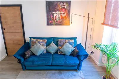 a blue couch with pillows in a living room at LE COCON DE JAURÈS entre Gare Croisette et Palais in Cannes