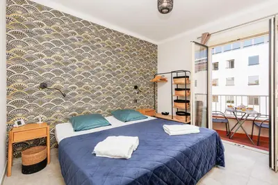 a bedroom with a blue bed and a wall at Duplex Charmant et Central Cannes Forville in Cannes