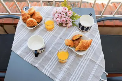 a table with plates of pastries and flowers and orange juice at Duplex Charmant et Central Cannes Forville in Cannes