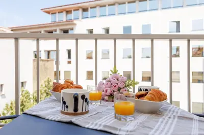 a table with breakfast foods and orange juice on a balcony at Duplex Charmant et Central Cannes Forville in Cannes