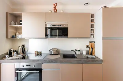 a kitchen with white cabinets and a sink at Duplex Charmant et Central Cannes Forville in Cannes