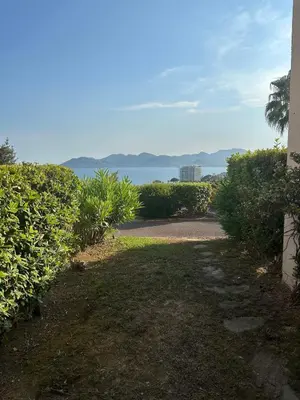 a path leading to a house with a view of the ocean at Renoir 252 - Appartement rez-de-jardin type F2 - Petite vue mer in Cannes