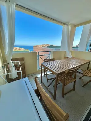 a balcony with a table and chairs and a view of the ocean at Ingres 158 - F3 vue mer Villa Francia in Cannes