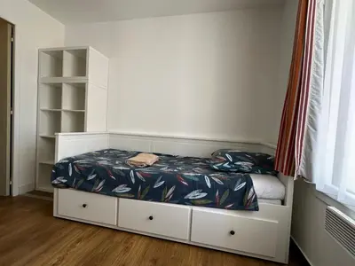 a small bedroom with a bed and a book shelf at Ingres 158 - F3 vue mer Villa Francia in Cannes