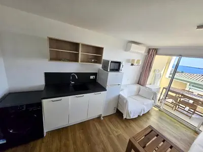 a kitchen with a sink and a living room with a balcony at Ingres 158 - F3 vue mer Villa Francia in Cannes