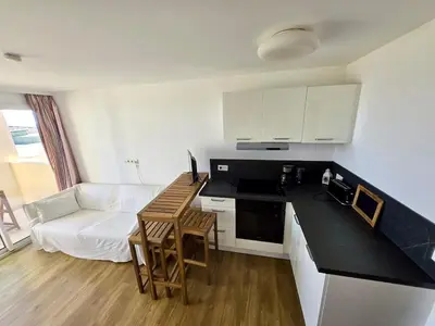 a kitchen and living room with a couch and a table at Ingres 158 - F3 vue mer Villa Francia in Cannes