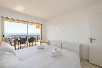 a white bedroom with a view of the ocean at 2-Br Apartment Sea View & Pool Cannes Croix des Gardes in Cannes