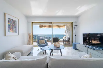 a living room with a couch and a tv at 2-Br Apartment Sea View & Pool Cannes Croix des Gardes in Cannes