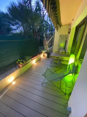 a deck with chairs and lights on a house at Le Baronne- Charmant studio climatisé au calme proche Plage et Palais des Festivals in Cannes