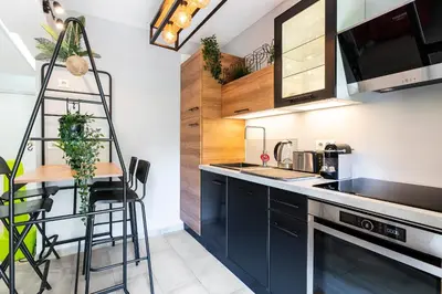 a kitchen with blue cabinets and a counter top at Le Baronne- Charmant studio climatisé au calme proche Plage et Palais des Festivals in Cannes