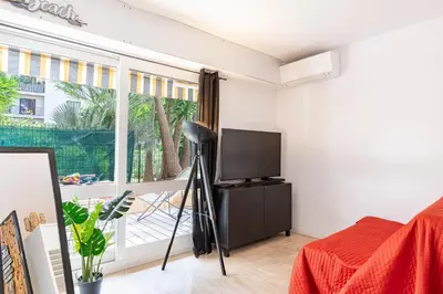 a room with a tv and a bed and a window at Le Baronne- Charmant studio climatisé au calme proche Plage et Palais des Festivals in Cannes