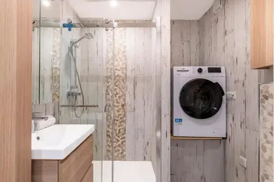 a bathroom with a washing machine in a shower at Le Baronne- Charmant studio climatisé au calme proche Plage et Palais des Festivals in Cannes