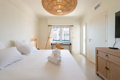 a bedroom with a white bed with towels on it at 2-Br Apartment with Terrace & Sea View Palm Beach Cannes in Cannes