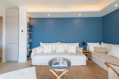 a living room with a couch and a table at 2-Br Apartment with Terrace & Sea View Palm Beach Cannes in Cannes