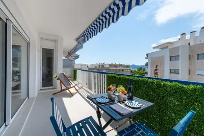 a patio with a table and chairs on a balcony at 2-Br Apartment with Terrace & Sea View Palm Beach Cannes in Cannes