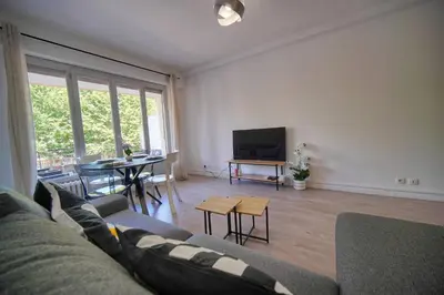 a living room with a couch and a tv and a table at FRGK Stanislas Apartment Terrace, Central Cannes AC & ULTRA FAST Wi-Fi in Cannes
