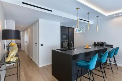 a kitchen with a counter with blue bar stools at LUXURY EQUINOX 3 Bedrooms in Cannes