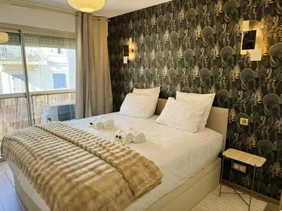 a bedroom with a bed with a black and white patterned wall at Newly Renovated 2BR Modern in Cannes