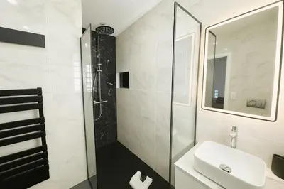 a white bathroom with a sink and a shower at Newly Renovated 2BR Modern in Cannes