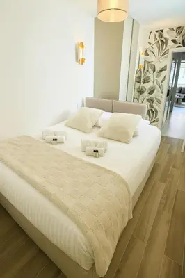 a bedroom with a large bed with white sheets at Newly Renovated 2BR Modern in Cannes