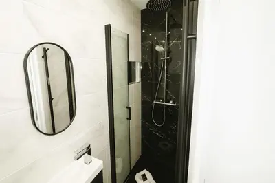 a bathroom with a shower and a sink and a mirror at Newly Renovated 2BR Modern in Cannes