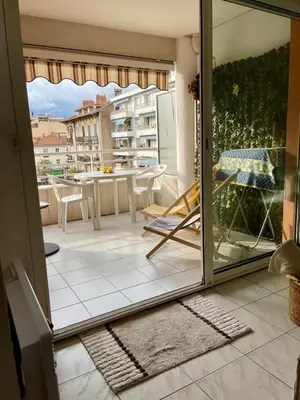 an open door to a balcony with a table and chairs at Appart avec terrasse in Cannes
