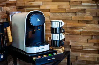a coffee maker on a table next to a wall at Appartement de standing, Piscine, Tennis, Plage in Cannes