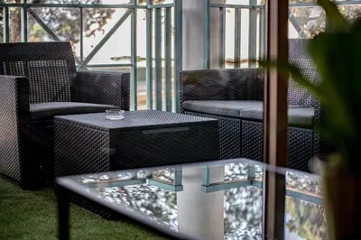 a balcony with two chairs and a table andwindows at Appartement de standing, Piscine, Tennis, Plage in Cannes