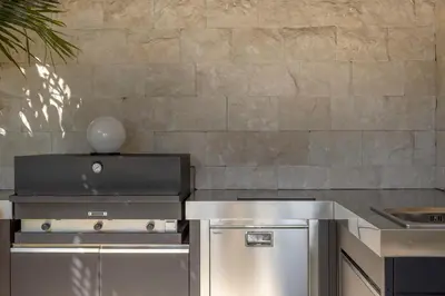 a kitchen with stainless steel appliances and a stone wall at REF 2176 - Cannes -Villa panoramic sea view in Cannes