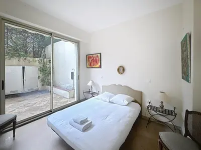 a bedroom with a bed and a large window at 3-bedroom apartment on La Croisette with garden in Cannes