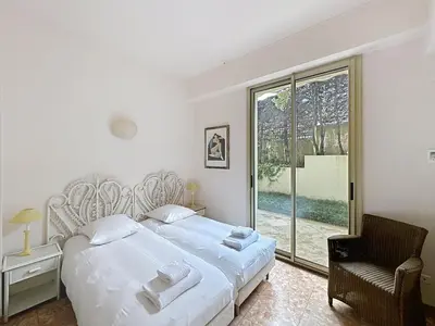 a bedroom with a large white bed and a window at 3-bedroom apartment on La Croisette with garden in Cannes