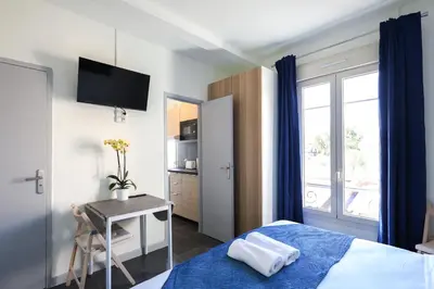a bedroom with a bed and a table and a window at Studio, centre ville Cannes in Cannes