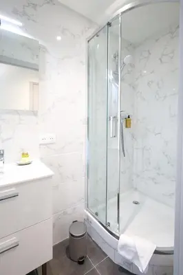 a white bathroom with a shower and a sink at Studio, centre ville Cannes in Cannes