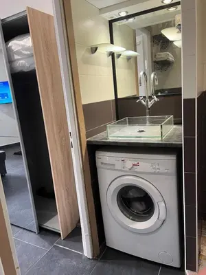 a laundry room with a washing machine and a mirror at Apparemment151 in Cannes