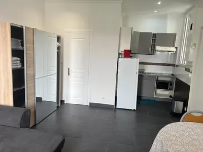 a kitchen with a white refrigerator in a room at Apparemment151 in Cannes
